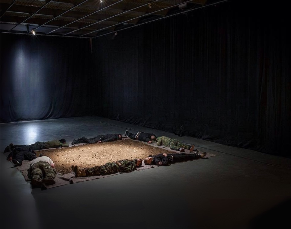 A square of earth with human bodies along its edges. G13, 2015.
