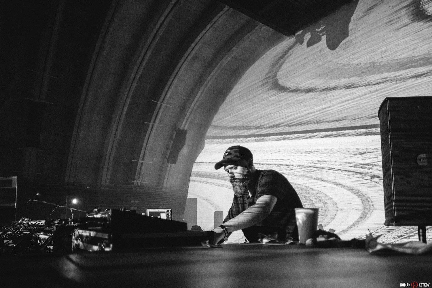 DJ set beneath an arched ceiling · SLEEK