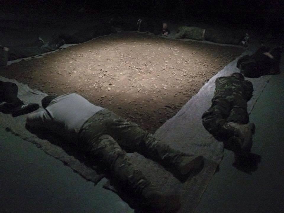Bodies surrounding a square of earth — installation detail.
